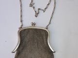 an antique silver mesh purse with a chain around it