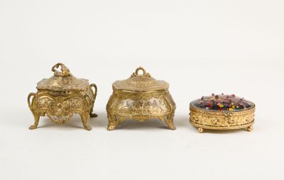 three pieces of gold and glass are sitting on a white surface