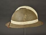 an old helmet on a stand on a gray background