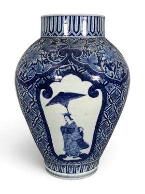 un vase bleu et blanc surmonté d'un oiseau