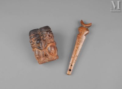 two carved wooden items on a gray surface with a wooden stick
