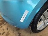 a close up of a blue car with a sticker on it
