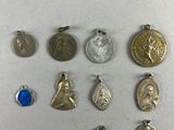 a group of silver and gold coins and charms on a white surface