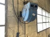 a blue blower hanging on the wall next to a pile of wood