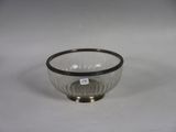 a small glass bowl with a black rim on a white surface