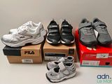 Plusieurs paires de chaussures sont posées sur des cartons, sur une table.