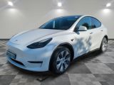 a white tesla suv parked in a garage with a checkered floor
