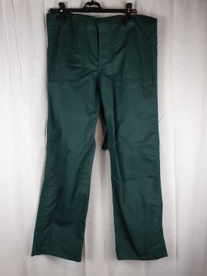 le pantalon vert est suspendu à un cintre accroché à un rideau blanc