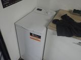 une petite machine à laver et un sèche-linge dans un coin de la pièce
