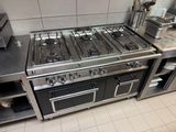 a kitchen with a stove, oven, and a microwave in it