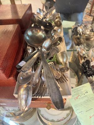 de nombreuses cuillères en argent et cuillères-cuillères exposées dans une vitrine
