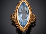 une bague en or sertie d'une topaze bleue au centre