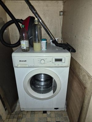 une machine à laver dans un coin d'une petite pièce