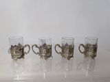 four glasses are lined up in a row on a table