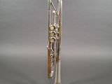 silver plated trumpet on stand on grey background with grey background
