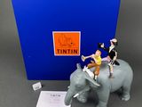 a figurine of a man riding on an elephant