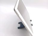 a tablet computer sitting on a stand on a white surface