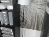 une étagère noire sur laquelle est posée une lampe, dans un coin de la pièce