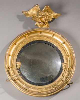 a gold mirror with an eagle on top of it