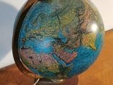 a small globe that is sitting on a wooden table