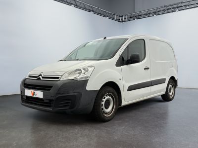 La camionnette blanche est garée dans une grande pièce blanche.