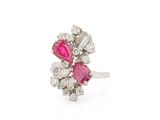 a close up of a diamond and ruby ring on a white background
