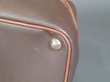 a brown and tan suitcase sitting on a blue surface