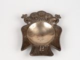 a silver plate with a bird on it on a white surface