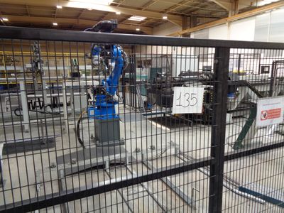 a blue robot that is in the middle of a factory