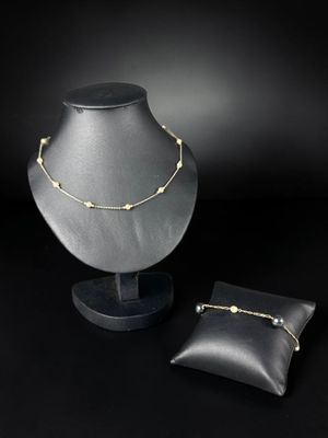 a necklace and a pillow on a black background