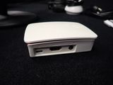 a white device sitting on a black surface next to a keyboard