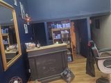 a photo of a barber shop with blue walls and wood floors
