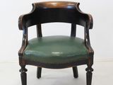 a green leather chair with a wooden frame on it