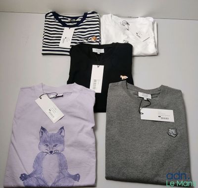 Quatre t-shirts avec un chat dessus sont posés sur une table