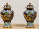 two vases with dragon designs on them on a table