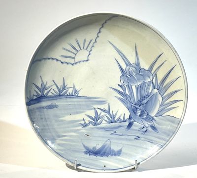 une assiette bleue et blanche ornée d'un oiseau et de fleurs