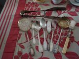 une table sur laquelle sont posés des couverts et recouverte d'une nappe rouge et blanche