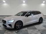 La Volvo break est garée dans une grande pièce au sol carrelé en damier.