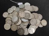 a pile of silver coins on a black surface