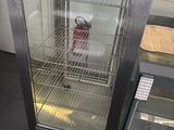 a glass display case with a fire extinguisor inside of it