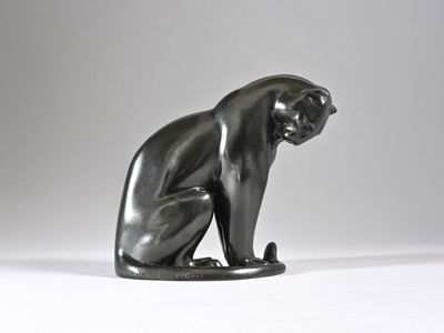 an image of a statue of a cat sitting on a white surface