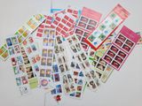 une pile de timbres posée sur une table, avec une épingle rouge