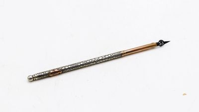 un gros plan d'un stylo sur une surface blanche avec un fond blanc