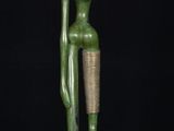 a green statue of a woman holding a bowl on her head