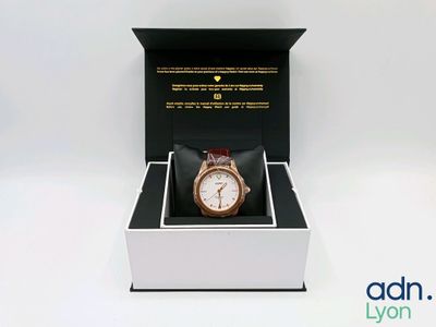a box with a watch inside of it on a white surface