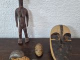 figurine en bois représentant un homme debout à côté d'autres objets posés sur une table en bois
