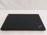 the back of a black laptop sitting on top of a white surface