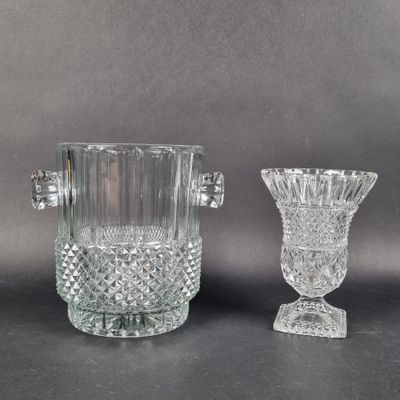 une paire de vases en cristal taillé munis d'anses, posés sur une table