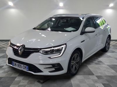 la voiture blanche est garée sur un sol en damier dans le garage
