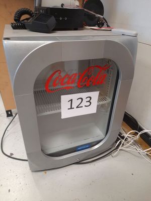 un distributeur de Coca-Cola sur lequel est apposée une étiquette indiquant le prix